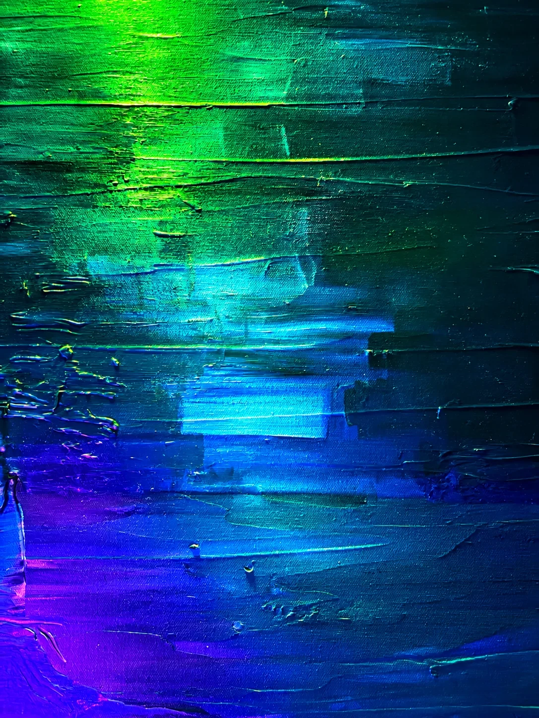 Layered strokes of green, teal, electric blue and violet paint under colored light