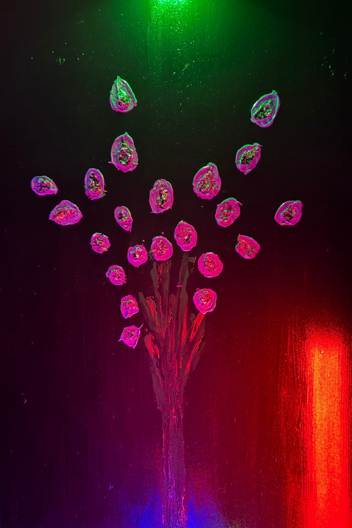 A bouquet of glowing pink blossoms on a black canvas lit by green and red light